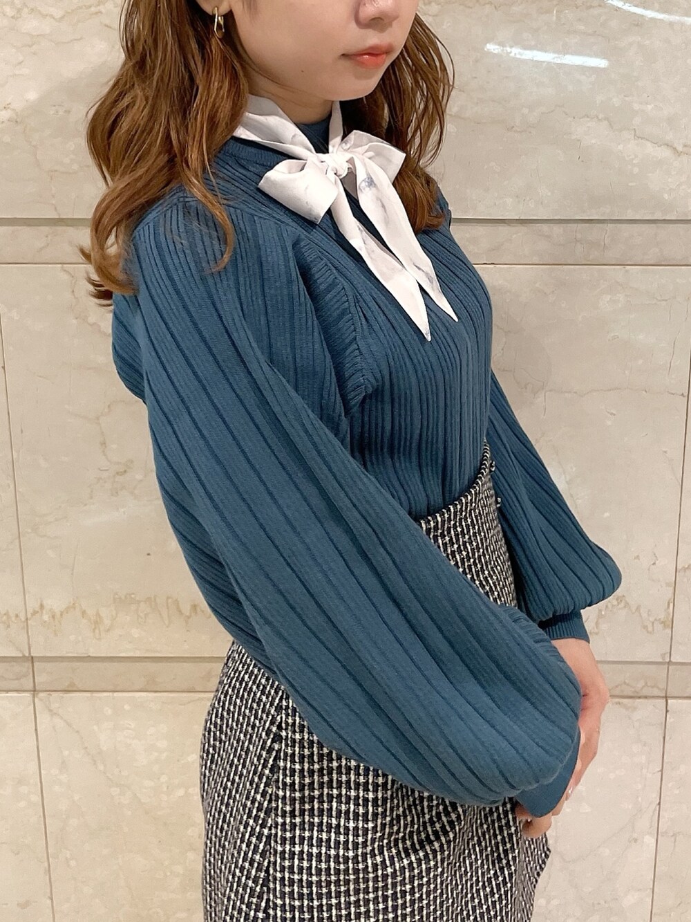 ブルー系のニット/セーター、ブラウン系のブーツ、ブルー系のスカートを着用したレディースの冬コーディネートの7枚目の写真