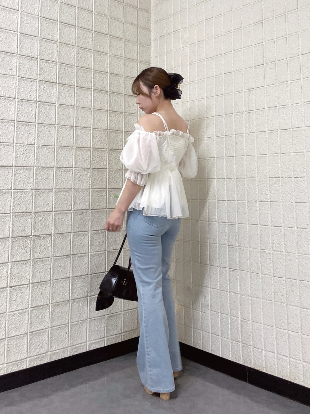 ホワイト系のシャツ/ブラウス、ブルー系のデニムパンツ、ブラウン系のサンダルを着用したレディースの春コーディネートの3枚目の写真