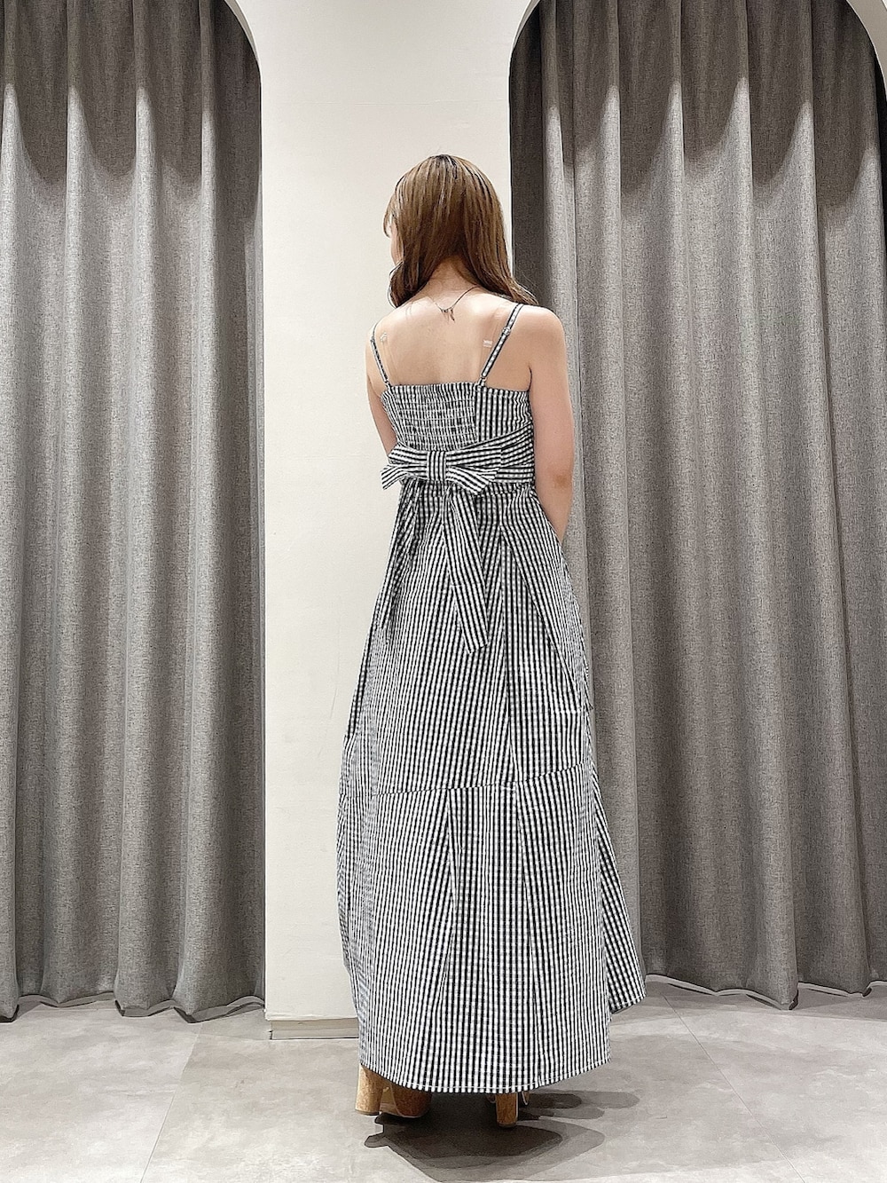 その他のワンピース、ホワイト系のハンドバッグ、ブラック系のサンダルを着用したレディースの夏コーディネートの3枚目の写真