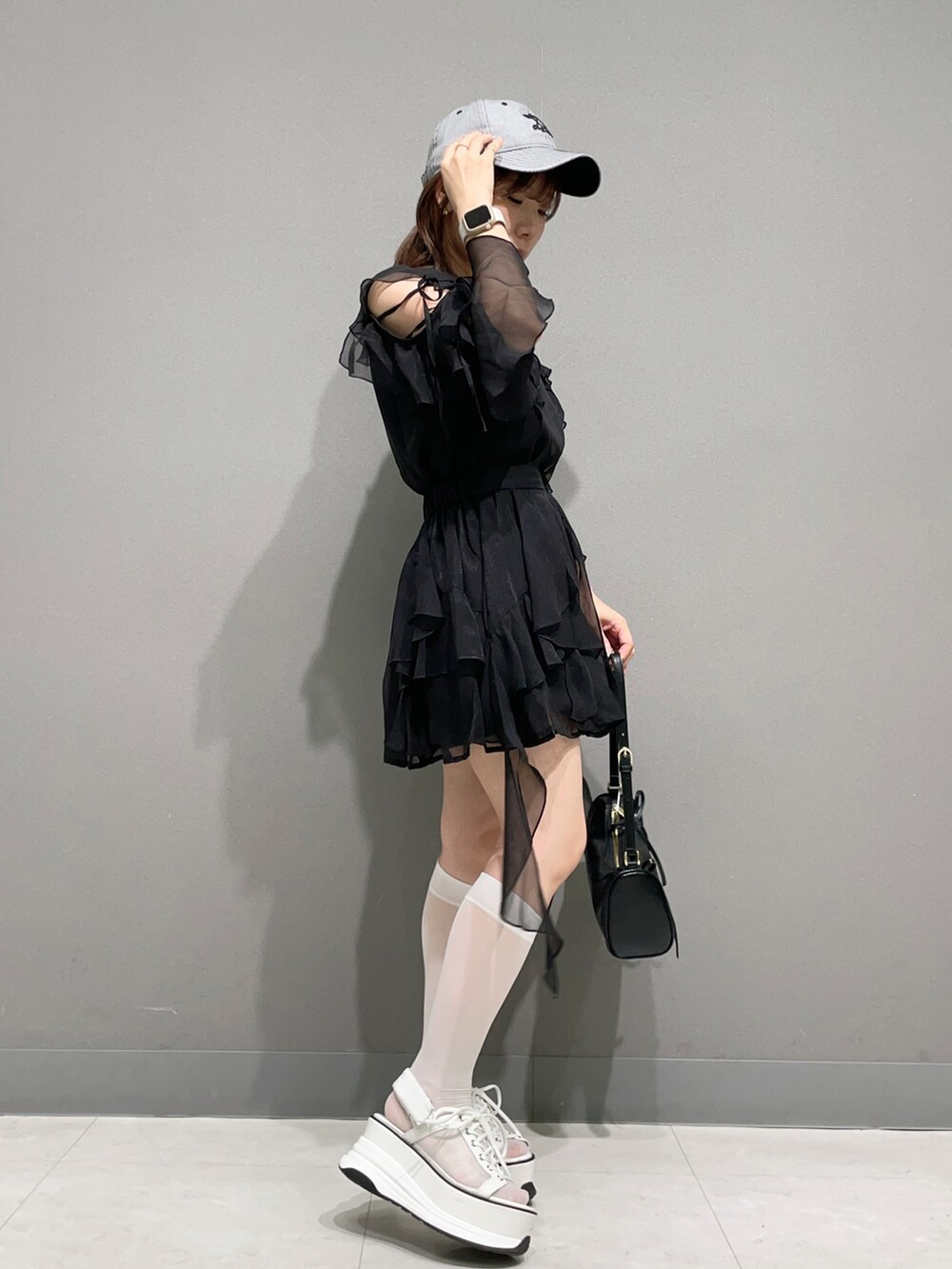 ブラック系のシャツ/ブラウス、ブラック系のスカート、ホワイト系のサンダルを着用したレディースの夏コーディネートの2枚目の写真