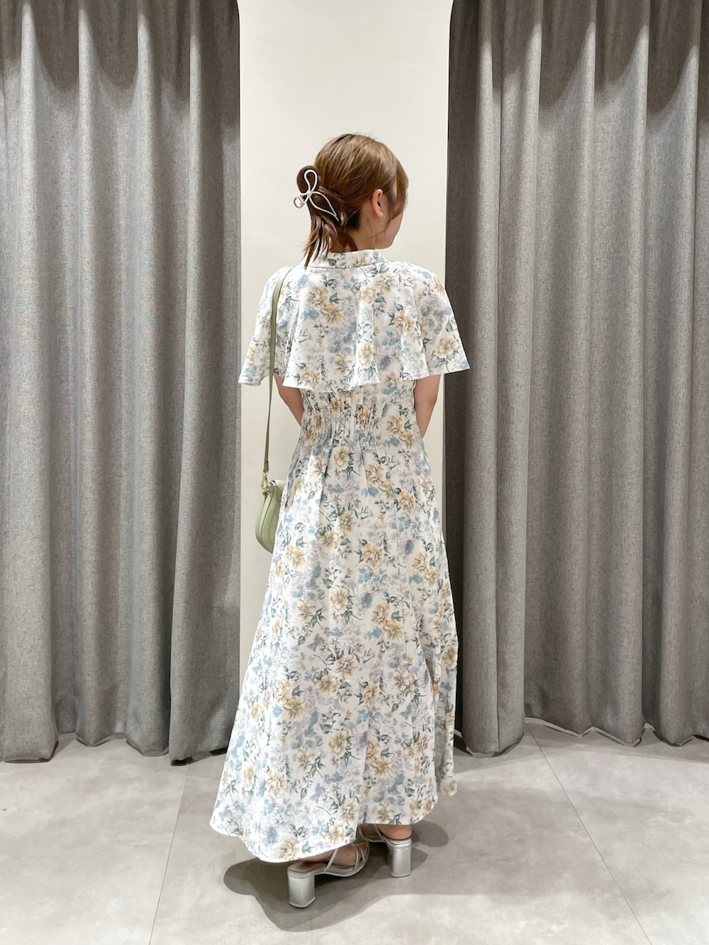 グリーン系のワンピース、グリーン系のハンドバッグ、シルバー系のパンプスを着用したレディースの夏コーディネートの4枚目の写真