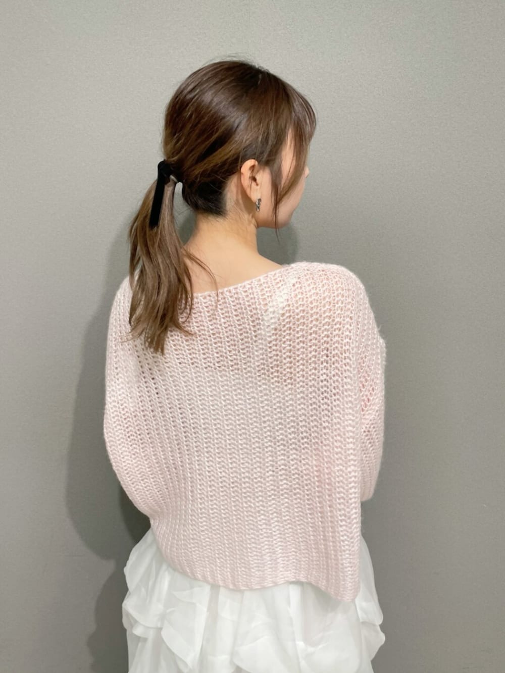 ピンク系のニット/セーター、ホワイト系のスカート、ホワイト系のブーツを着用したレディースの秋コーディネートの7枚目の写真