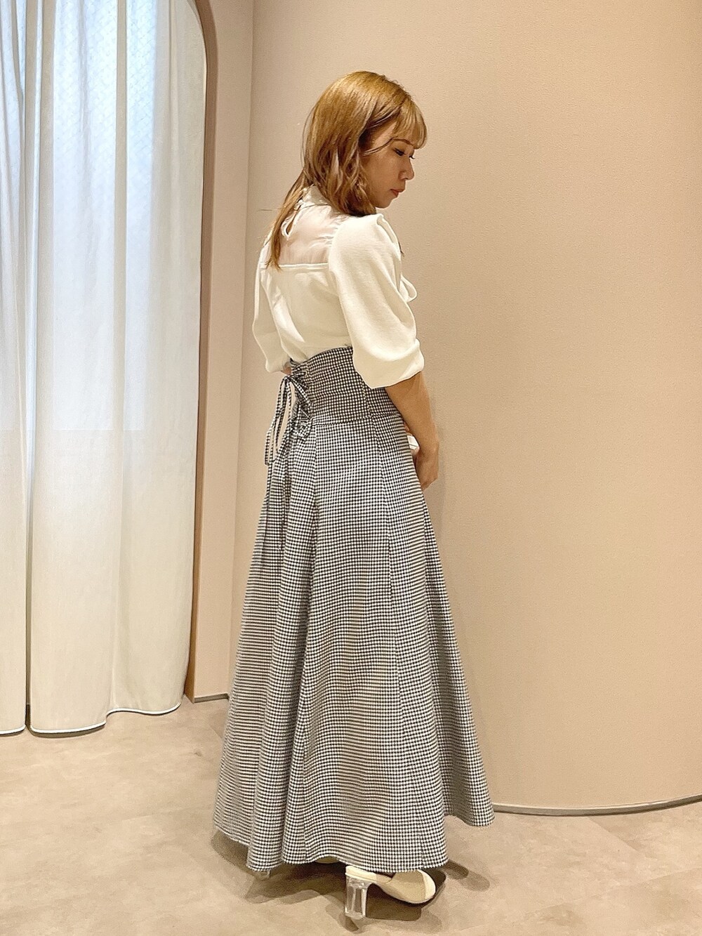 ホワイト系のニット/セーター、ブラック系のスカート、その他のパンプスを着用したレディースの冬コーディネートの4枚目の写真