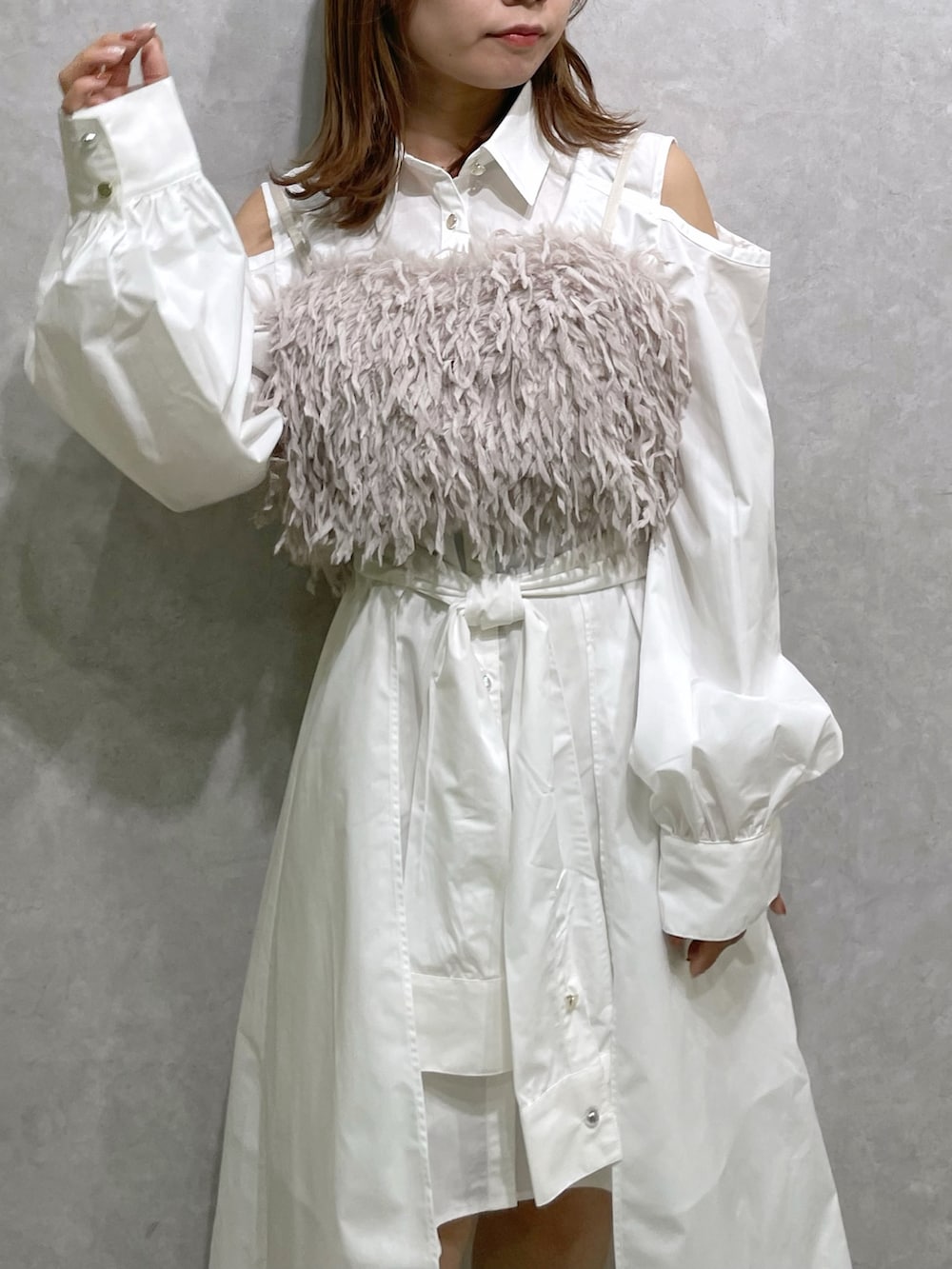 ホワイト系のシャツワンピース、ピンク系のキャミソール、ベージュ系のブーツを着用したレディースの秋コーディネートの5枚目の写真