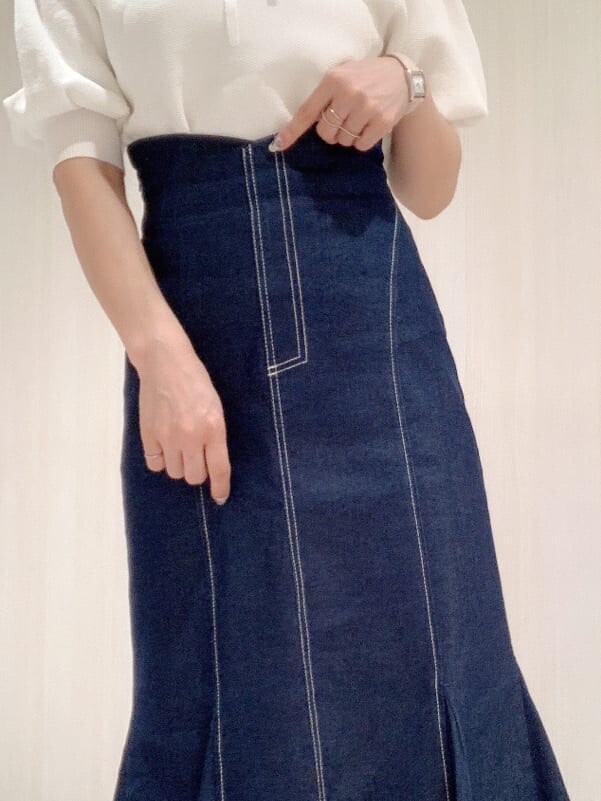 ブルー系のスカート、ホワイト系のニット/セーター、ベージュ系のサンダルを着用したレディースの春コーディネートの6枚目の写真