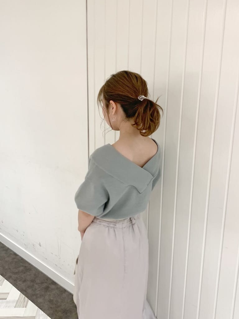 グレー系のスカート、グリーン系のニット/セーター、ホワイト系のローファーを着用したレディースの春コーディネートの6枚目の写真