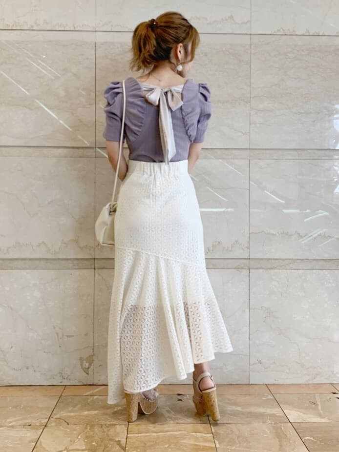 その他のサンダル、ホワイト系のスカート、ホワイト系のハンドバッグを着用したレディースの春コーディネートの2枚目の写真