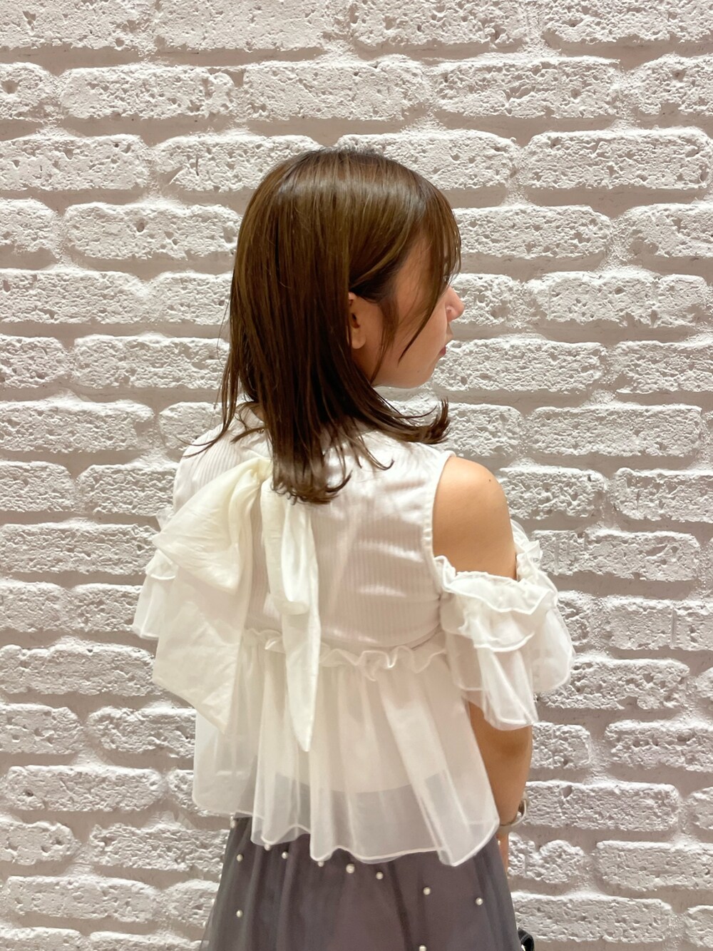 ホワイト系のTシャツ/カットソー、ブラック系のパンプス、ブラック系のハンドバッグを着用したレディースの夏コーディネートの7枚目の写真