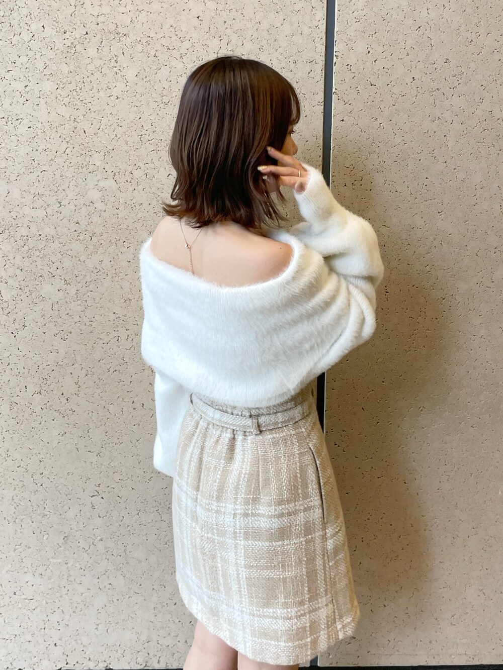 ホワイト系のニット/セーター、ベージュ系のスカート、ベージュ系のブーツを着用したレディースの秋コーディネートの6枚目の写真