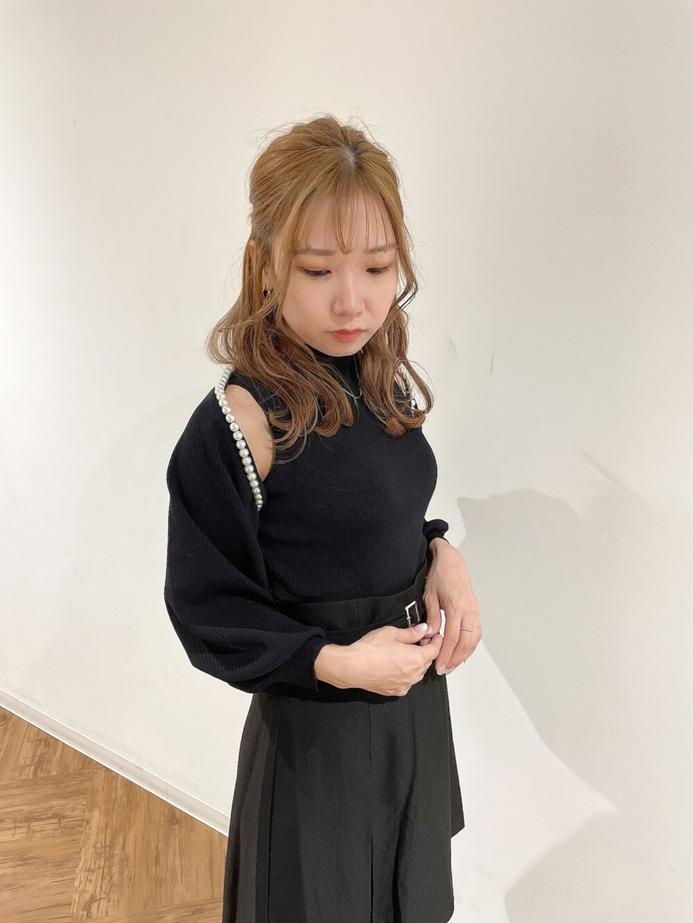 ブラック系のスカート、ブラック系のニット/セーター、ブラック系のブーツを着用したレディースの冬コーディネートの4枚目の写真