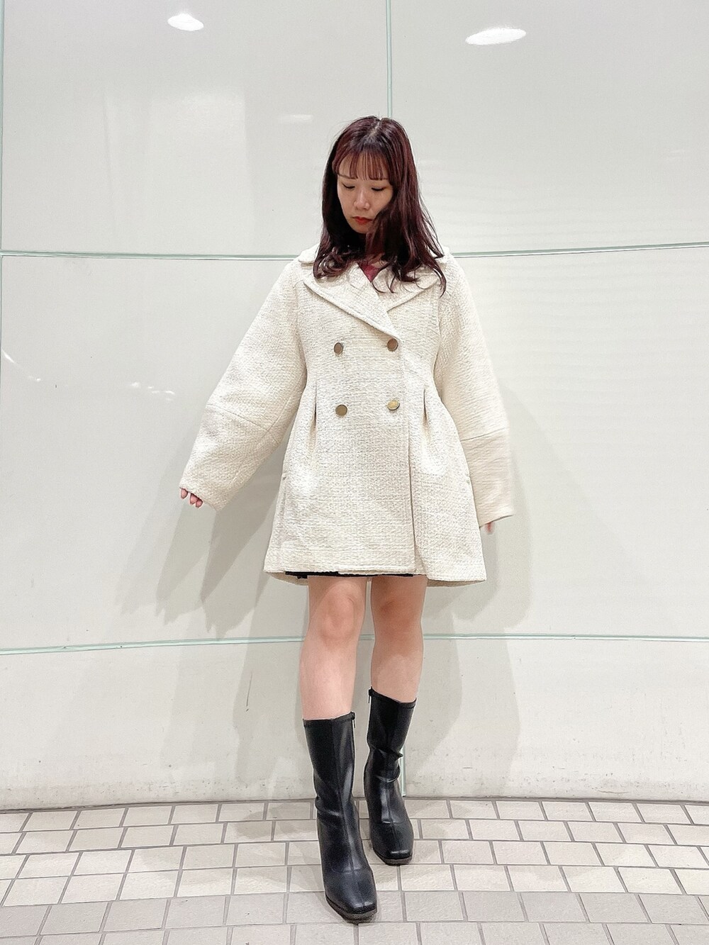 ピンク系のニット/セーター、グレー系のスカート、ホワイト系のその他アウターを着用したレディースの秋コーディネートの4枚目の写真