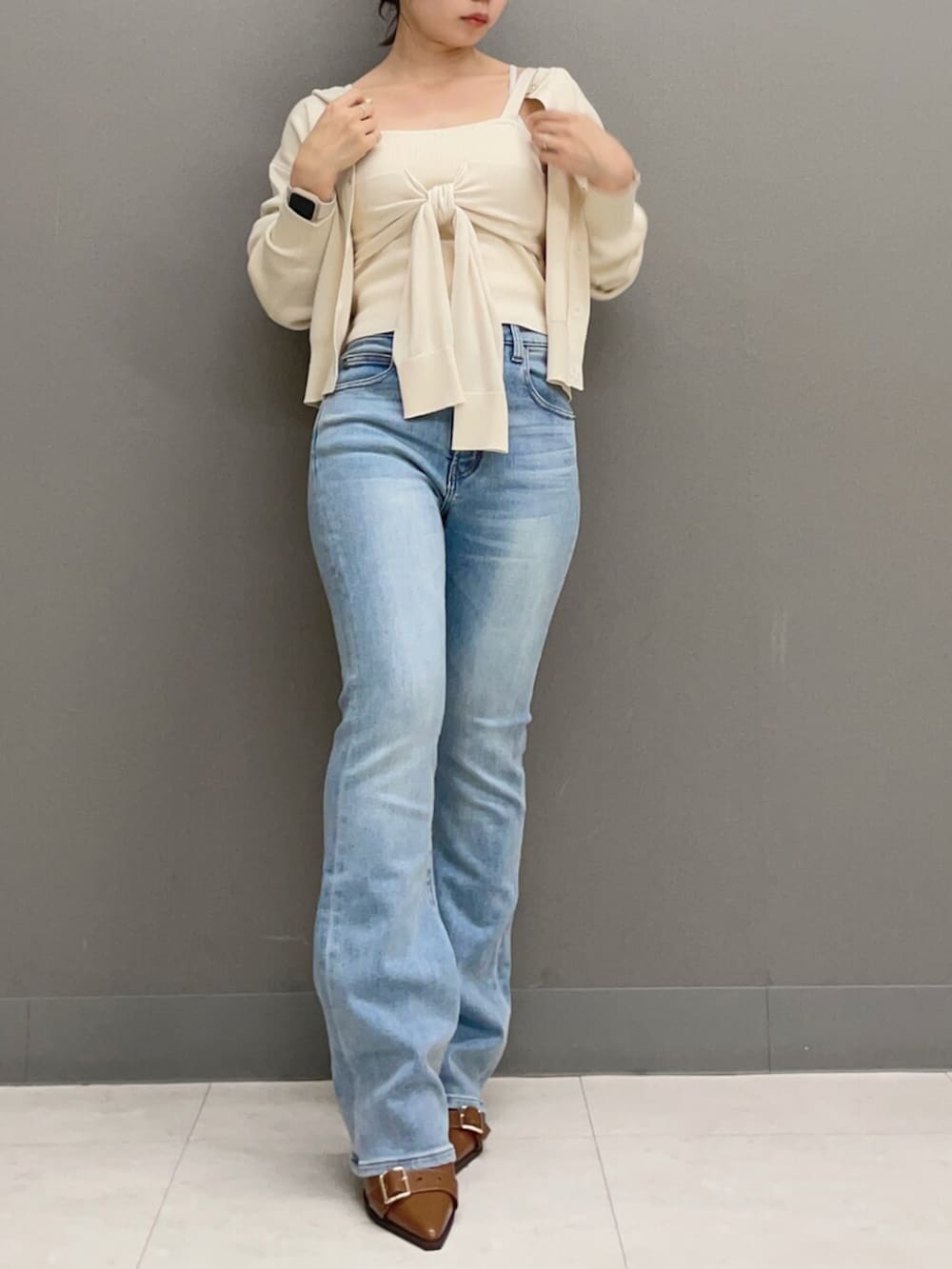 ホワイト系のキャミソール、ホワイト系のカーディガン/ボレロ、ブルー系のデニムパンツを着用したレディースの秋コーディネートの2枚目の写真