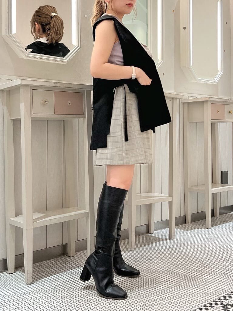 グレー系のスカート、パープル系のニット/セーター、ブラック系のベストを着用したレディースの夏コーディネートの2枚目の写真