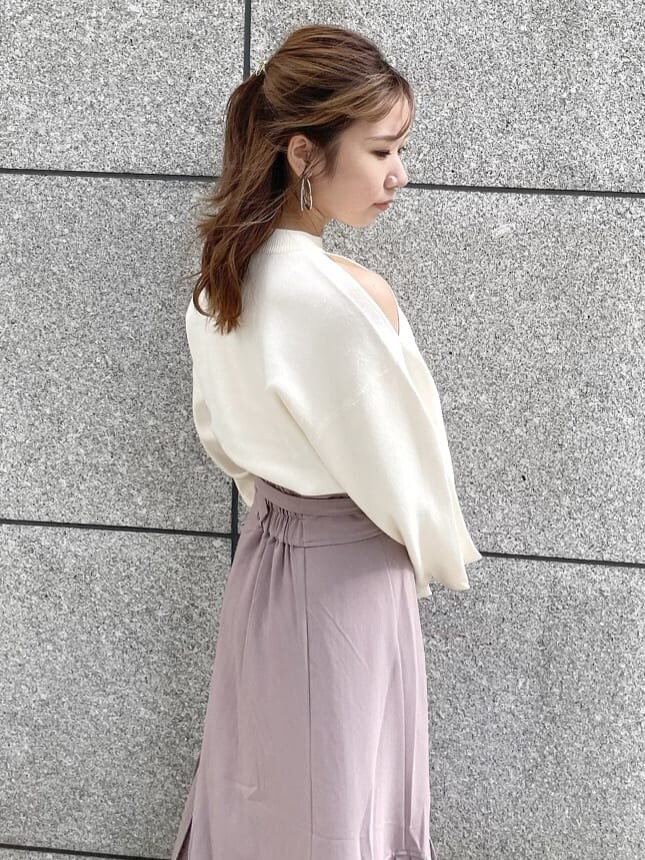 ベージュ系のスカート、ブラック系のブーツ、ホワイト系のキャミソールを着用したレディースの秋コーディネートの6枚目の写真