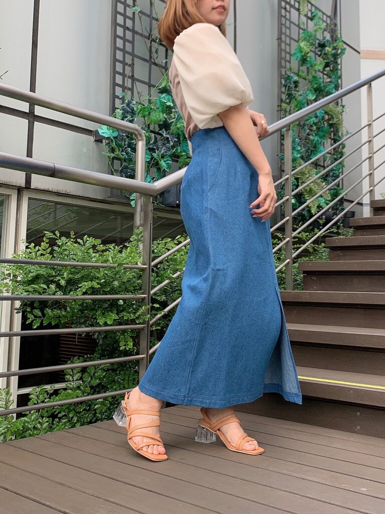 ブルー系のスカート、オレンジ系のサンダル、ベージュ系のTシャツ/カットソーを着用したレディースの春コーディネートの2枚目の写真