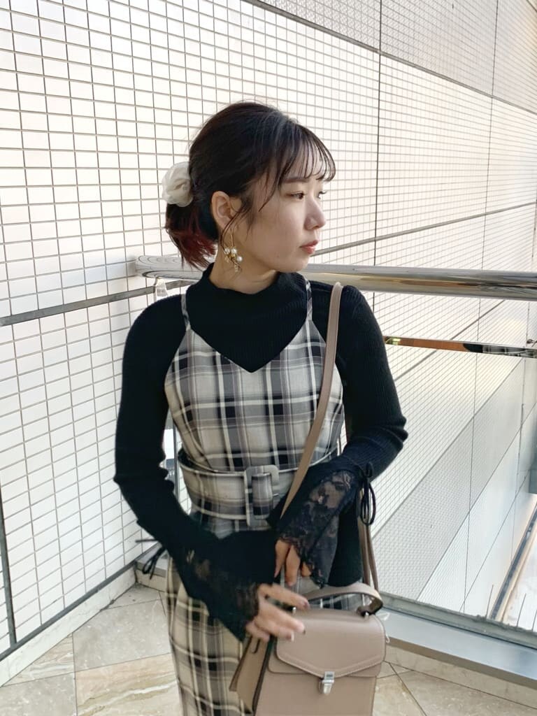 ブラック系のブーツ、グレー系のジャンパースカート、ブラック系のニット/セーターを着用したレディースの冬コーディネートの5枚目の写真