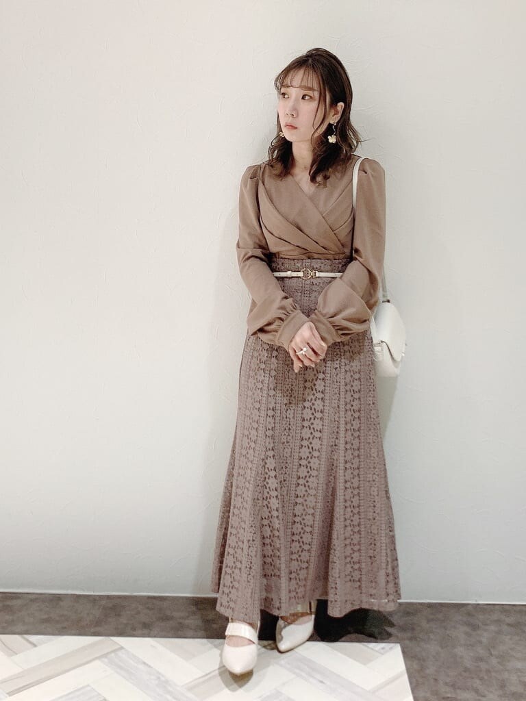 ブラウン系のワンピース、ホワイト系のパンプス、ホワイト系のショルダーバッグを着用したレディースの冬コーディネートの2枚目の写真