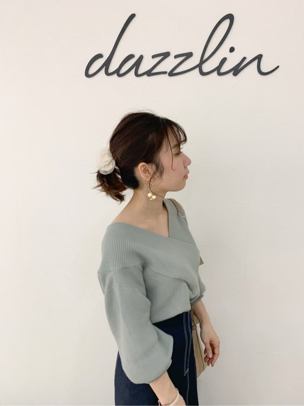 ブラック系のブーツ、ベージュ系のハンドバッグ、グリーン系のニット/セーターを着用したレディースの冬コーディネートの6枚目の写真