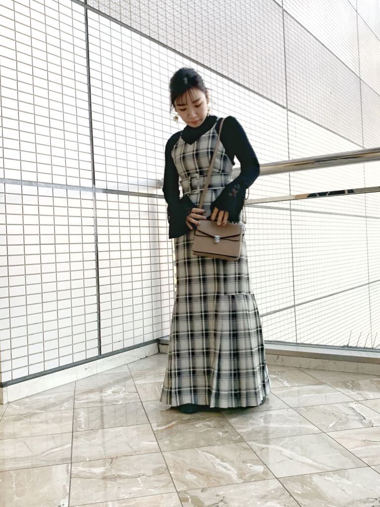 ブラック系のブーツ、グレー系のジャンパースカート、ブラック系のニット/セーターを着用したレディースの冬コーディネートの2枚目の写真