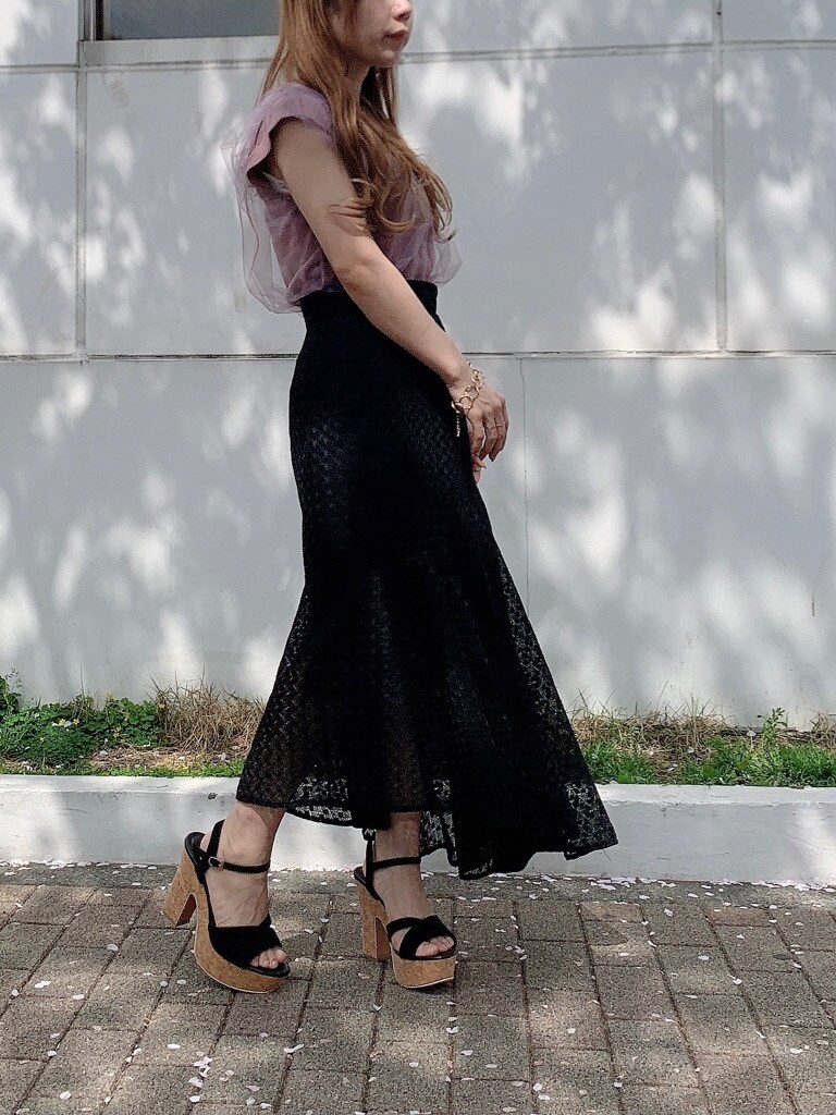 ブラック系のサンダル、ピンク系のニット/セーター、ブラック系のスカートを着用したレディースの春コーディネートの2枚目の写真