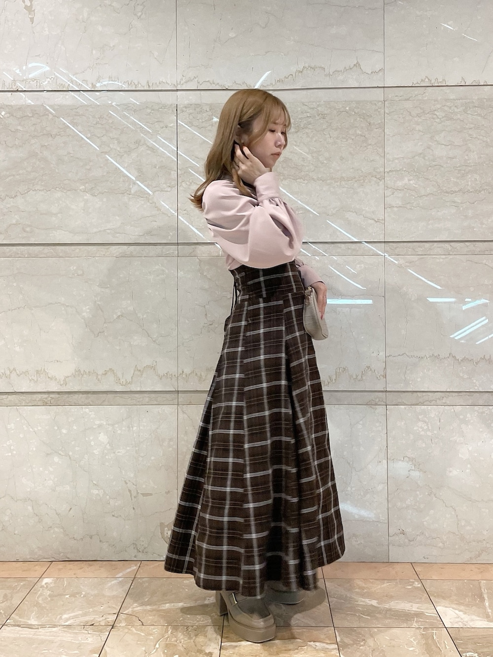 ピンク系のシャツ/ブラウス、ブラウン系のスカート、ベージュ系のローファーを着用したレディースの冬コーディネートの3枚目の写真