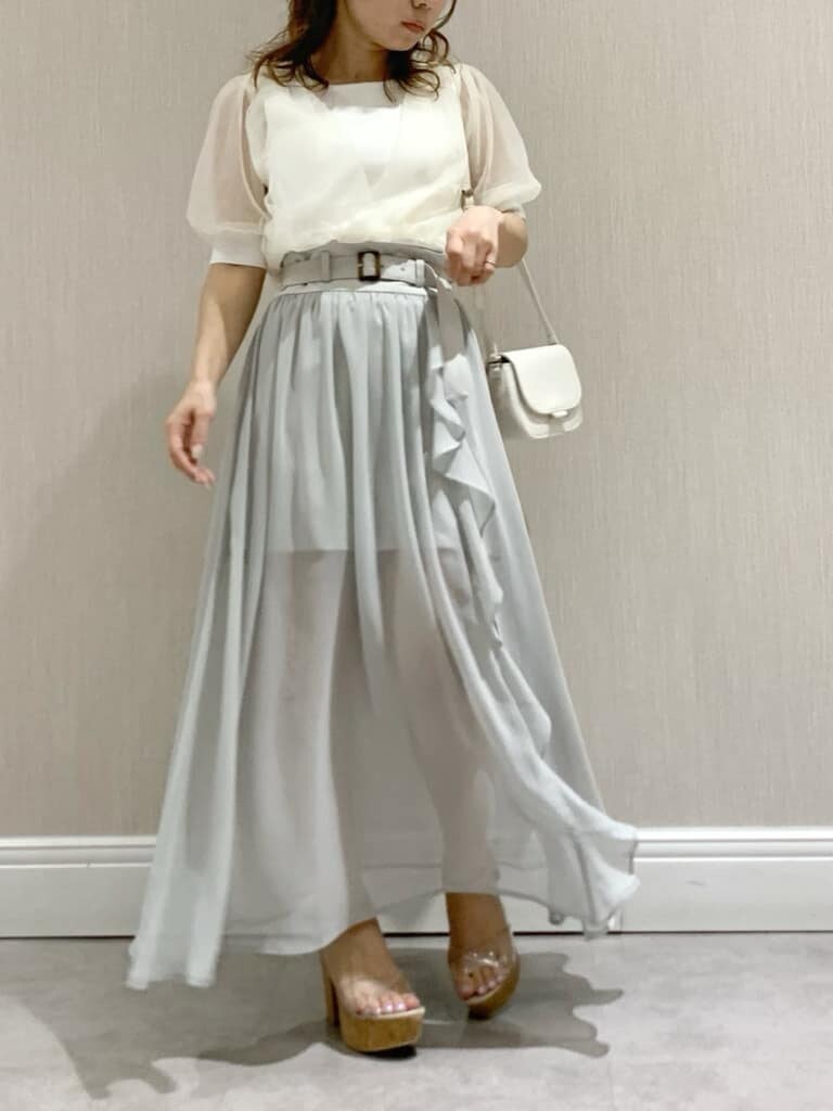 ホワイト系のニット/セーター、ホワイト系のショルダーバッグ、グレー系のスカートを着用したレディースの春コーディネートの2枚目の写真