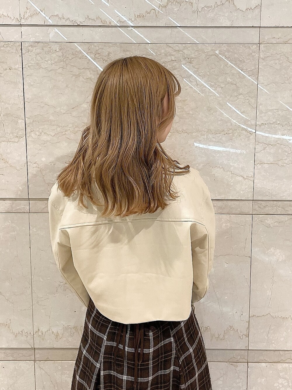 ホワイト系のライダースジャケット、ピンク系のシャツ/ブラウス、ブラウン系のスカートを着用したレディースの冬コーディネートの9枚目の写真