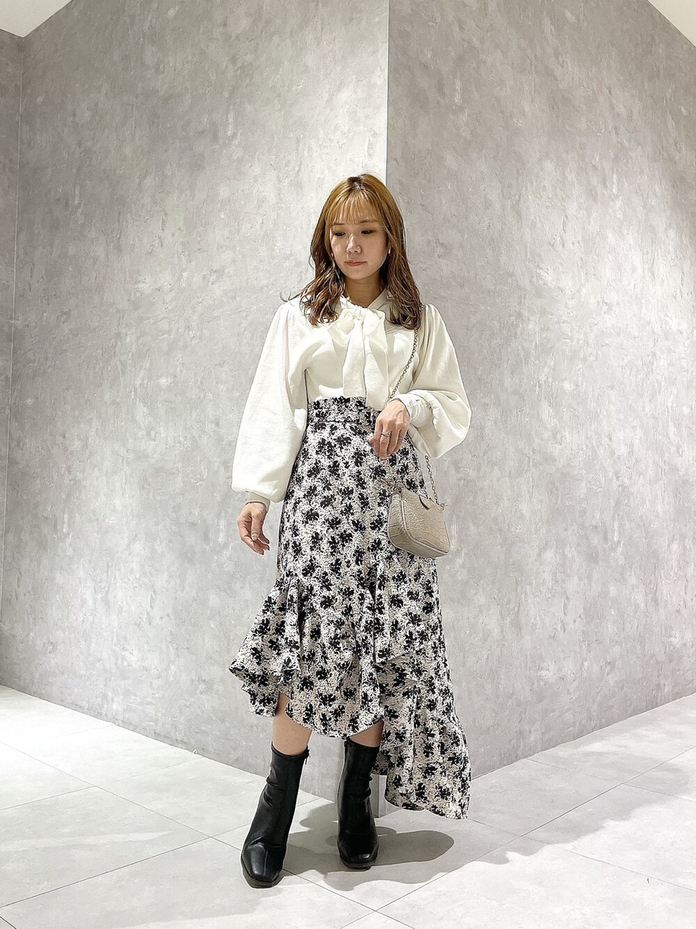 ホワイト系のニット/セーター、その他のスカート、ブラック系のブーツを着用したレディースの秋コーディネートの4枚目の写真