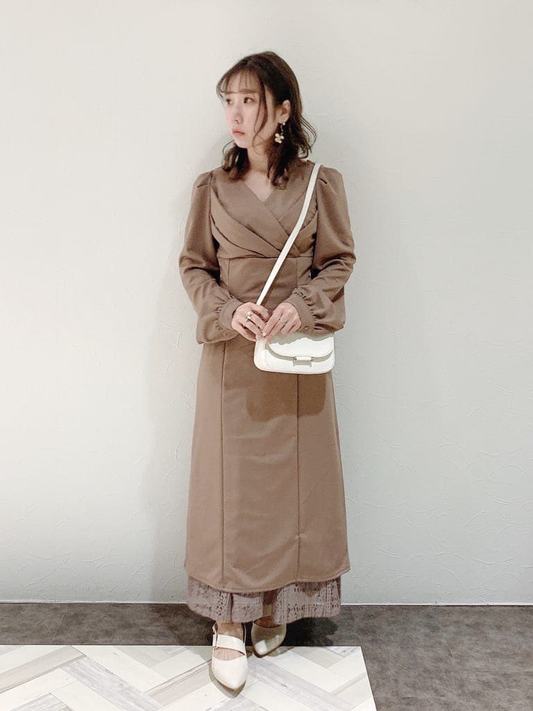 ブラウン系のワンピース、ホワイト系のパンプス、ホワイト系のショルダーバッグを着用したレディースの冬コーディネートの4枚目の写真