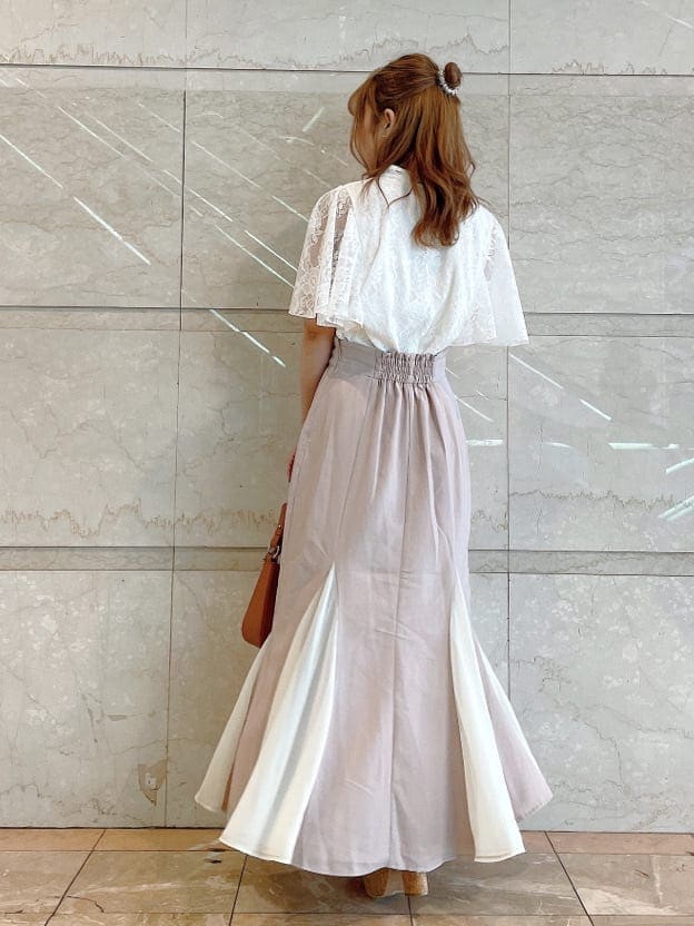 ブラウン系のハンドバッグ、ホワイト系のシャツ/ブラウス、ベージュ系のサンダルを着用したレディースの夏コーディネートの3枚目の写真