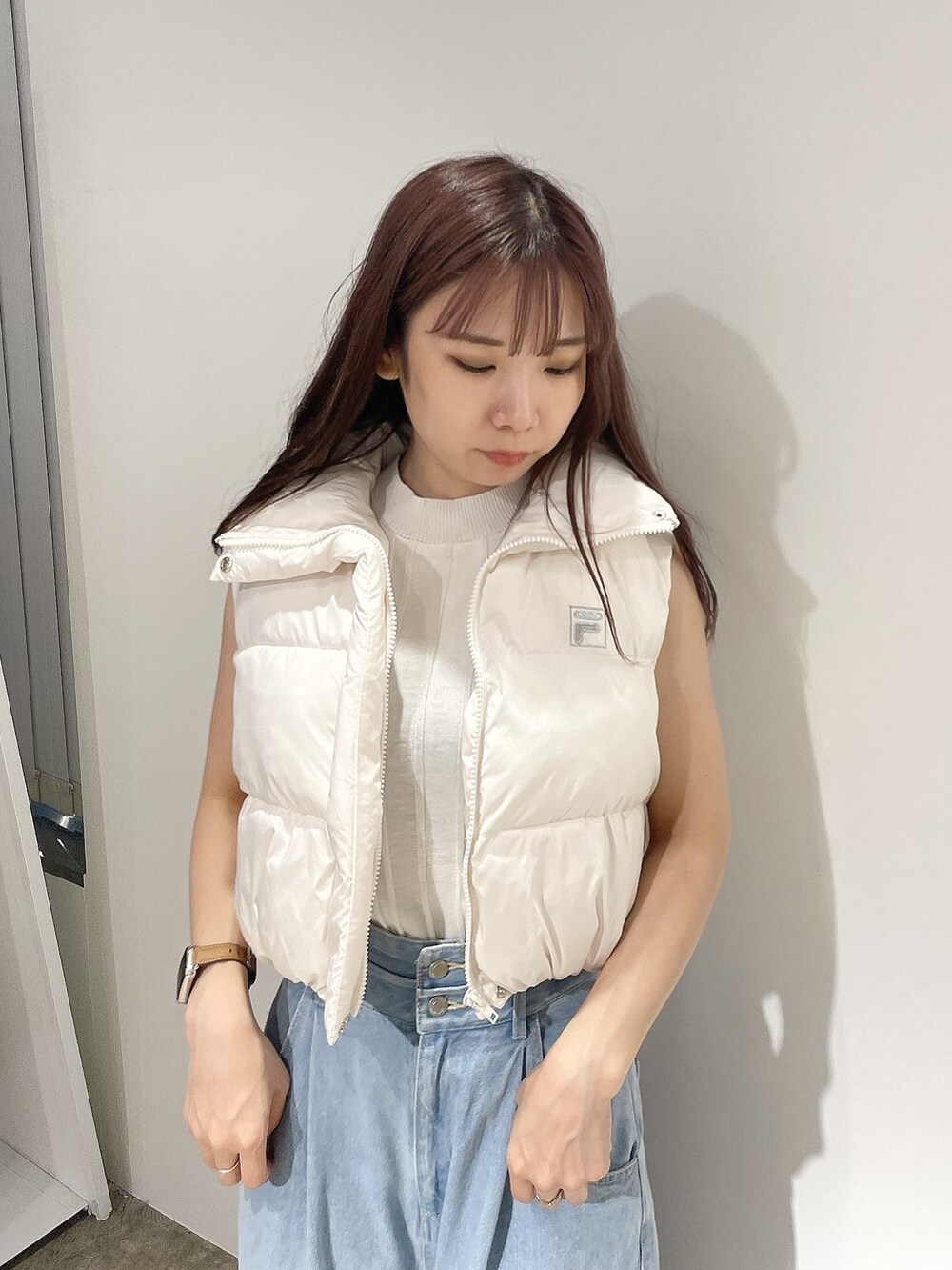 ブルー系のデニムパンツ、ホワイト系のニット/セーター、ホワイト系のベストを着用したレディースの夏コーディネートの5枚目の写真
