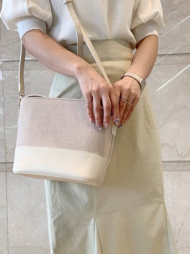 グリーン系のスカート、ホワイト系のパンプス、ホワイト系のハンドバッグを着用したレディースの春コーディネートの8枚目の写真