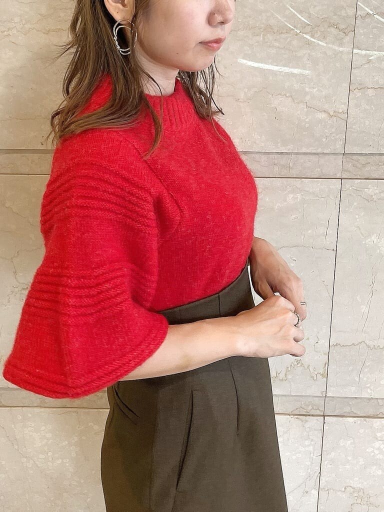 レッド系のニット/セーター、ブラウン系のスカート、ベージュ系のブーツを着用したレディースの秋コーディネートの7枚目の写真