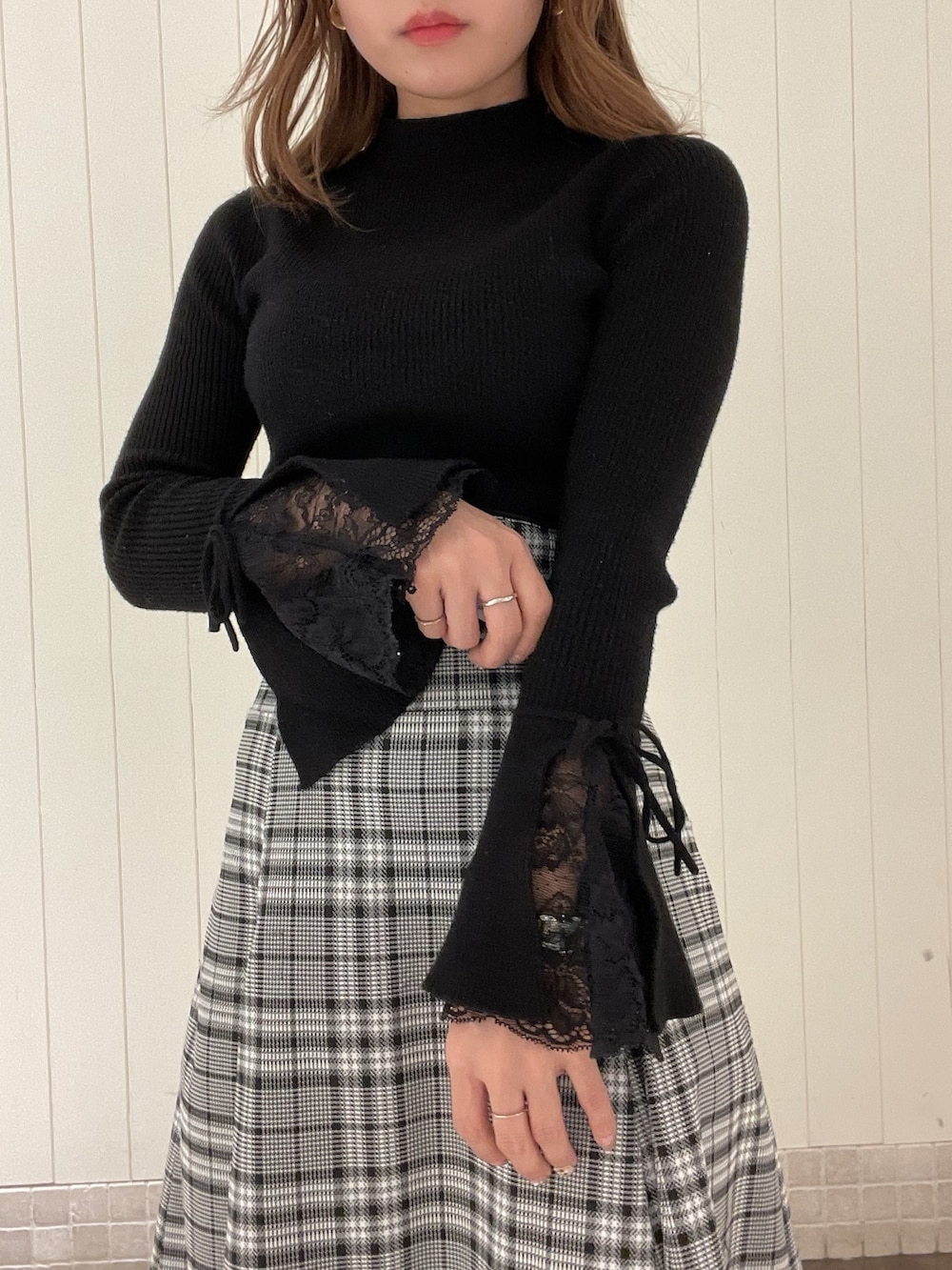 ブラック系のニット/セーター、グレー系のスカート、ブラック系のブーツを着用したレディースの秋コーディネートの5枚目の写真