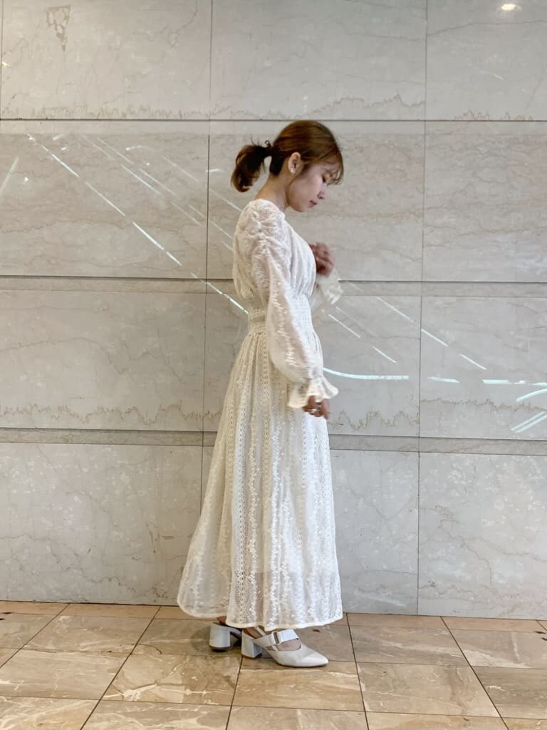 ベージュ系のテーラードジャケット、ホワイト系のワンピース、ホワイト系のパンプスを着用したレディースの冬コーディネートの2枚目の写真