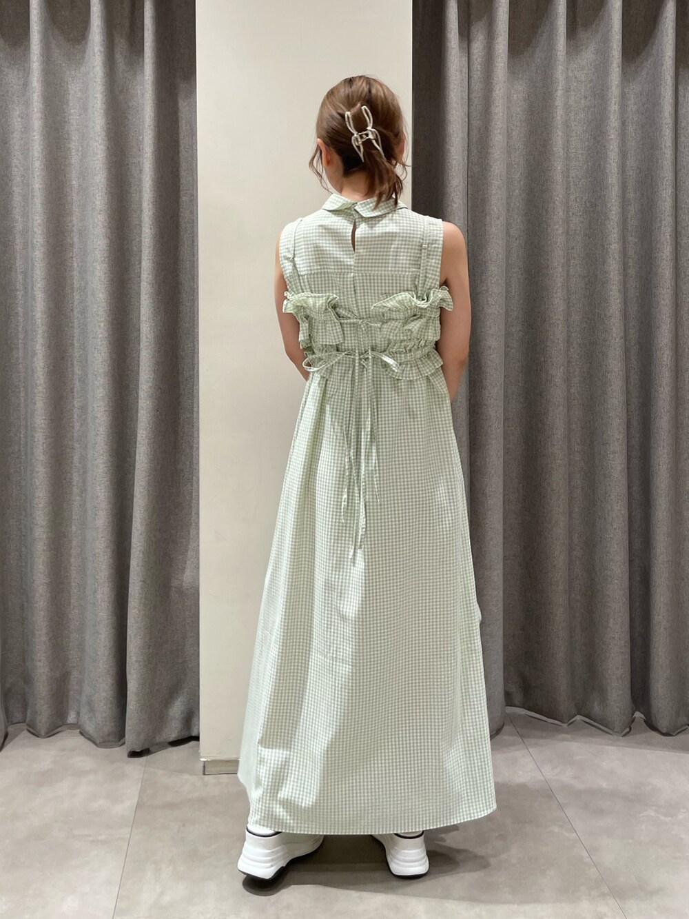 ホワイト系のハンドバッグ、ホワイト系のサンダル、グリーン系のシャツワンピースを着用したレディースの夏コーディネートの4枚目の写真