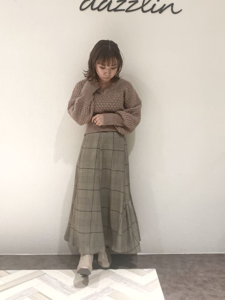 ブラウン系のスカート、ベージュ系のブーツ、ベージュ系のニット/セーターを着用したレディースの秋コーディネートの3枚目の写真