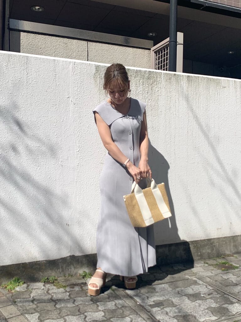 グレー系のワンピース、ホワイト系のサンダル、ホワイト系のハンドバッグを着用したレディースの春コーディネートの4枚目の写真