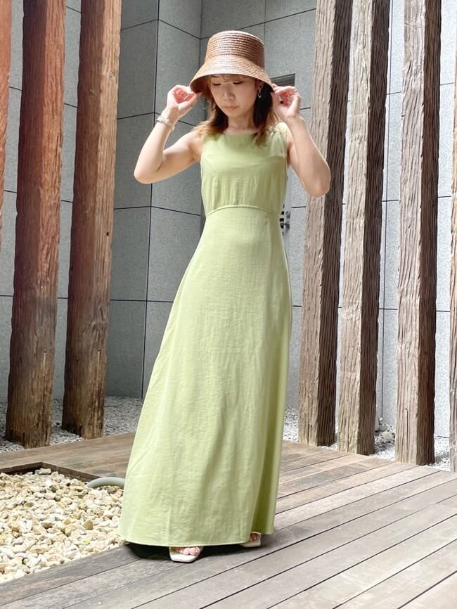 パープル系のサンダル、グリーン系のワンピース、シルバー系のピアス（両耳用）を着用したレディースの夏コーディネートの2枚目の写真