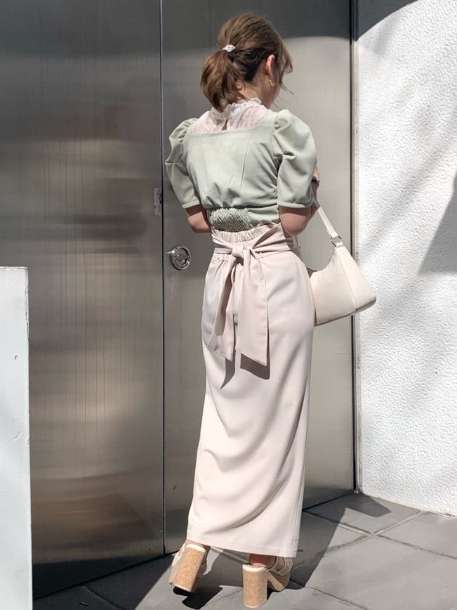 ベージュ系のスカート、グリーン系のTシャツ/カットソー、ホワイト系のサンダルを着用したレディースの春コーディネートの3枚目の写真