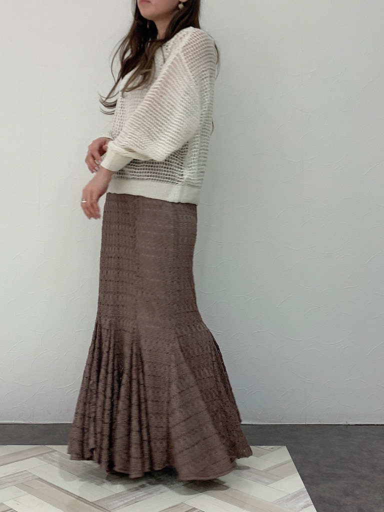 ベージュ系のスカート、ブラウン系のパンプス、ホワイト系のニット/セーターを着用したレディースの春コーディネートの3枚目の写真