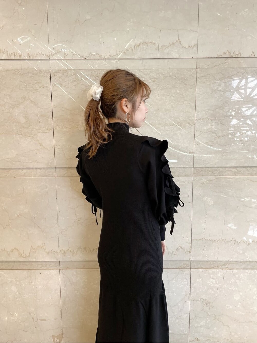 ベージュ系のブーツ、ブラック系のワンピース、ゴールド系のピアス（両耳用）を着用したレディースの秋コーディネートの7枚目の写真