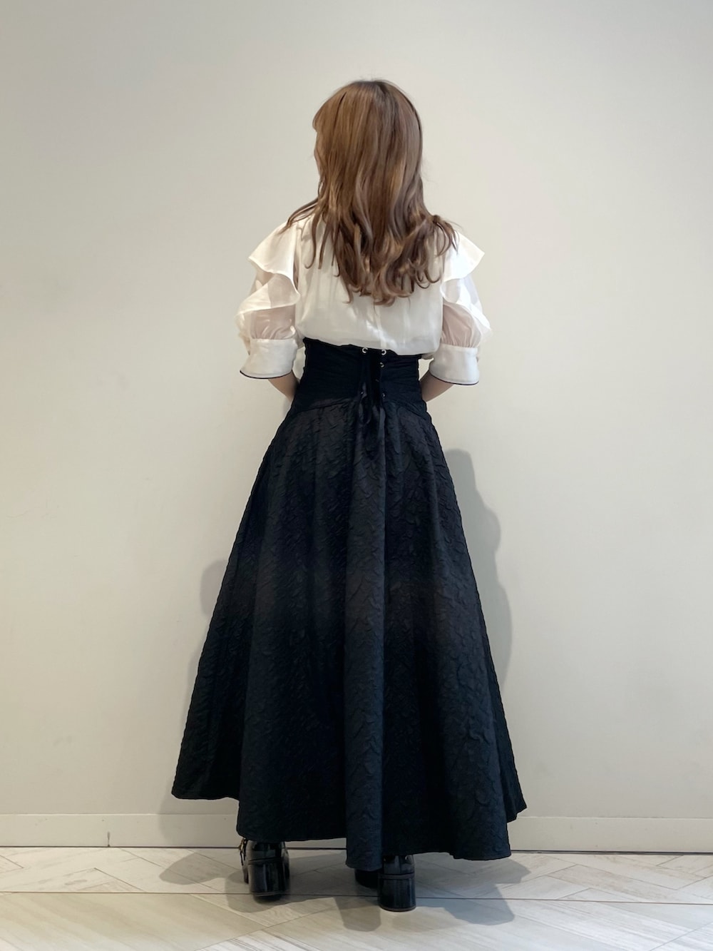 ホワイト系のシャツ/ブラウス、ブラック系のスカート、ブラック系のパンプスを着用したレディースの夏コーディネートの3枚目の写真