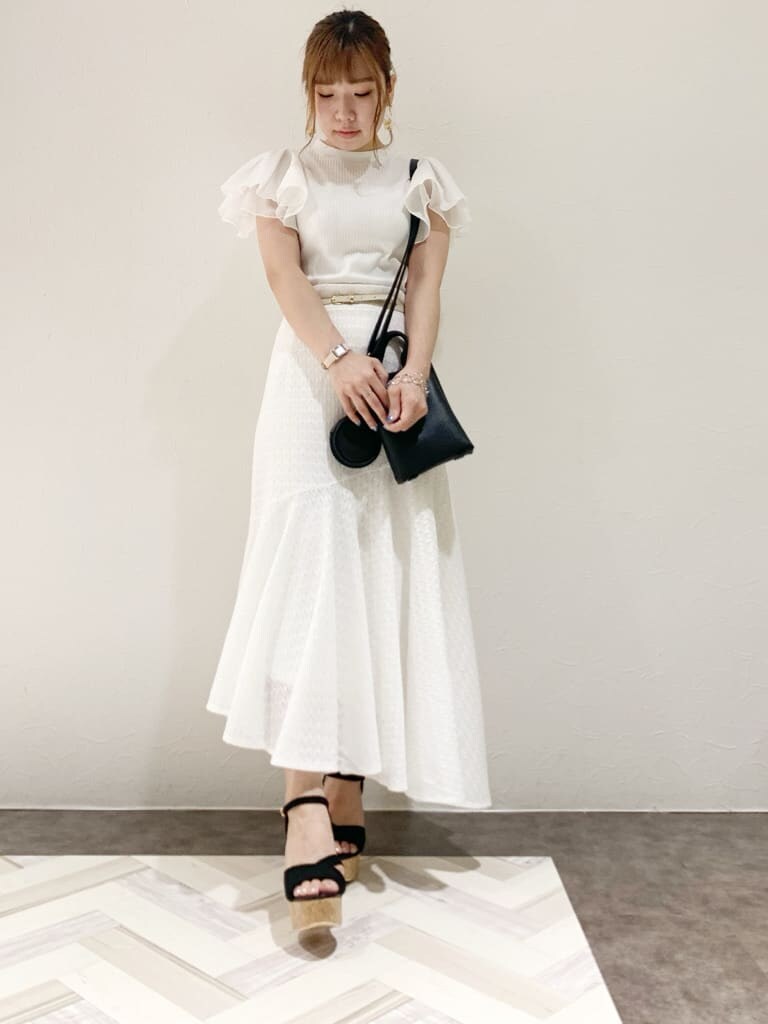 その他のサンダル、ブラック系のハンドバッグ、ホワイト系のTシャツ/カットソーを着用したレディースの夏コーディネートの2枚目の写真