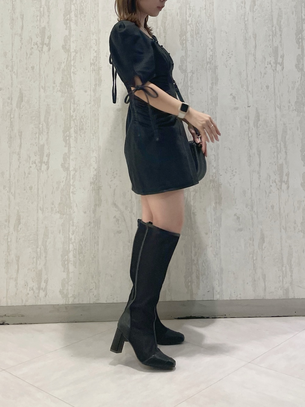 ブラック系のハンドバッグ、ブラック系のブーツ、ブラック系のワンピースを着用したレディースの夏コーディネートの4枚目の写真