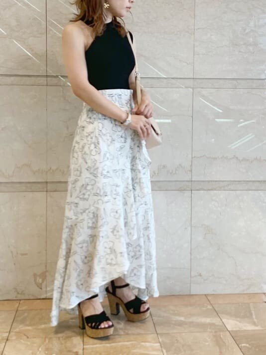 ブラック系のサンダル、ベージュ系のショルダーバッグ、ホワイト系のスカートを着用したレディースの春コーディネートの4枚目の写真