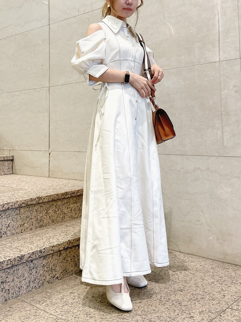 ホワイト系のワンピース、ホワイト系のパンプス、イエロー系のハンドバッグを着用したレディースの冬コーディネートの3枚目の写真