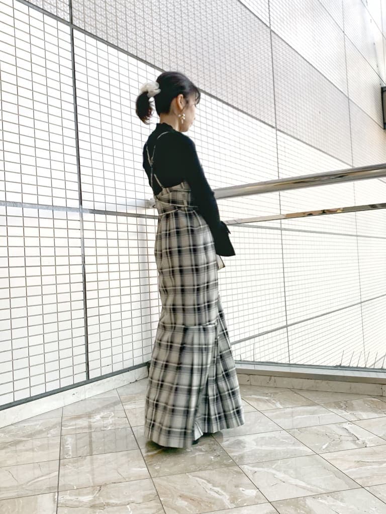 ブラック系のブーツ、グレー系のジャンパースカート、ブラック系のニット/セーターを着用したレディースの冬コーディネートの3枚目の写真