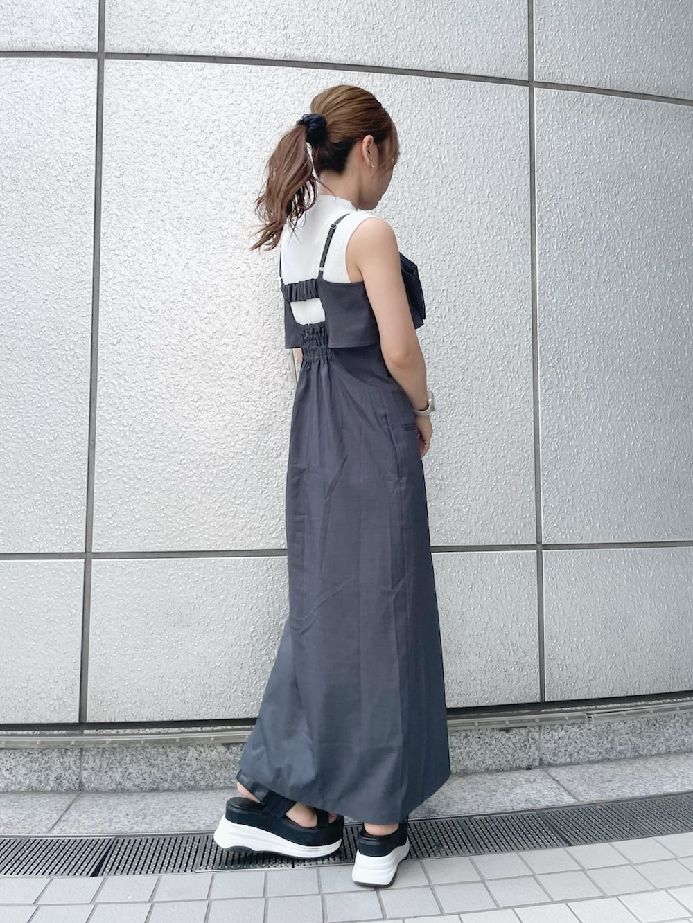 ホワイト系のニット/セーター、グレー系のワンピース、ブラック系のサンダルを着用したレディースの夏コーディネートの4枚目の写真