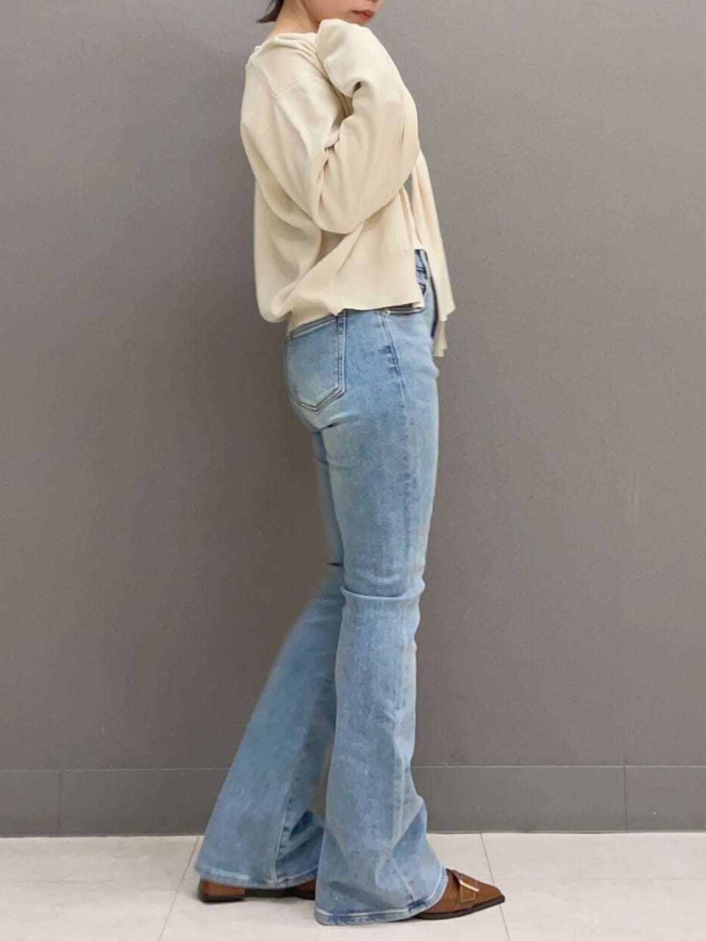 ホワイト系のキャミソール、ホワイト系のカーディガン/ボレロ、ブルー系のデニムパンツを着用したレディースの秋コーディネートの3枚目の写真